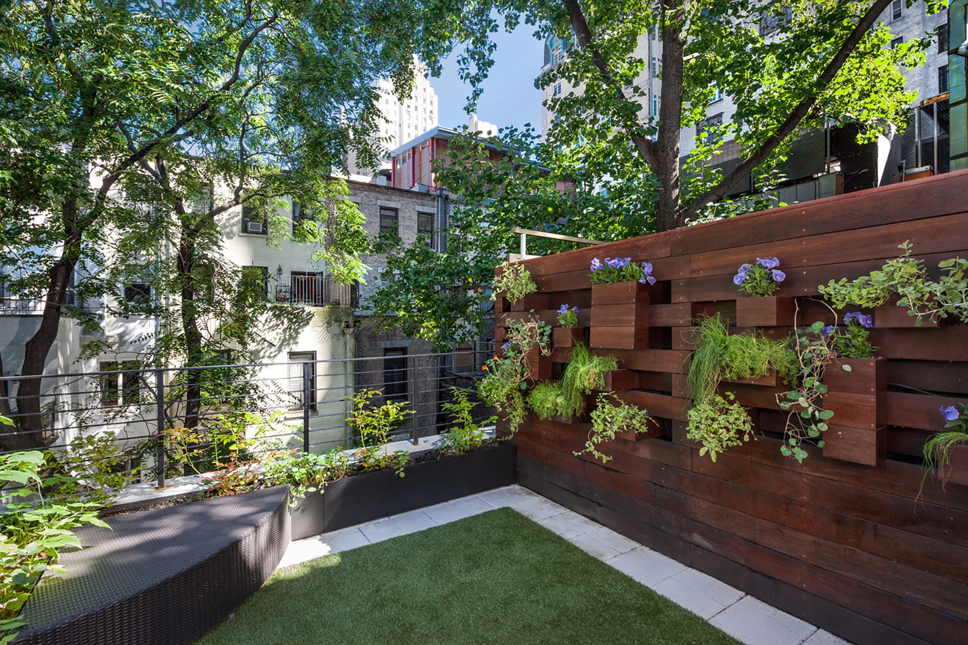 Rear terrace with a custom fence with planters and a grass area